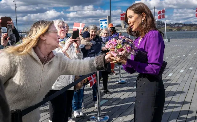 Queen Mary wore a purple amethyst wrap silk blouse by Jesper Hovring, and black midi skirt