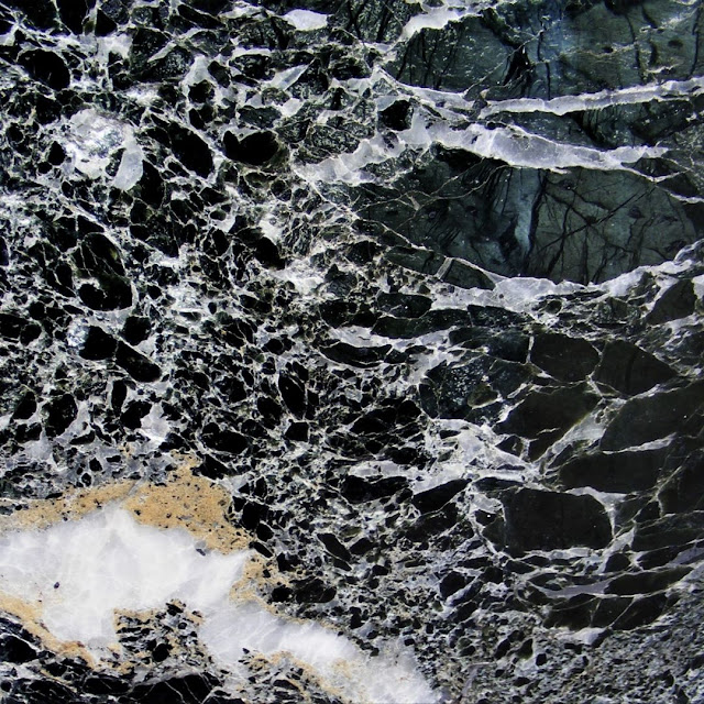 A slab of polished serpentinite with lots of mineral veins cutting across it