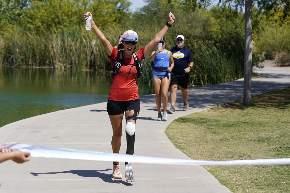 Jacky Hunt-Broersma finishes her 102nd marathon in 102 days, this one at Veterans Oasis Park, Thursday, April 28, 2022, in Chandler, Ariz. (AP Photo/Ross D. Franklin)
