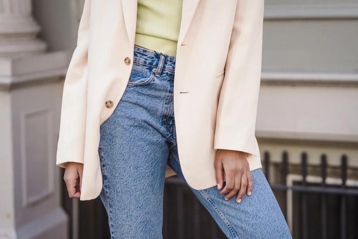 close-up of woman outfit in jeans and oversized nude jacket