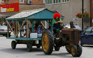 image Millbrook Ontario Fair Parade entry Tractor driven by clown pulling float past Home Hardware