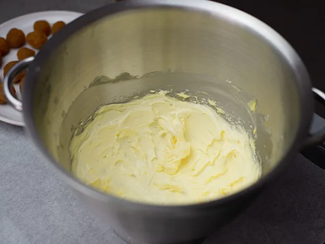 Cream butter with icing sugar until pale and creamy.