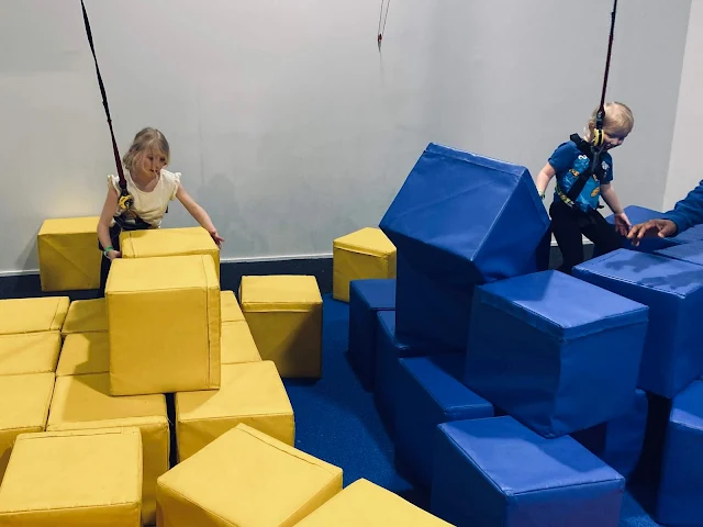 Large blocks in yellow and blue being built up into a tower to climb up 