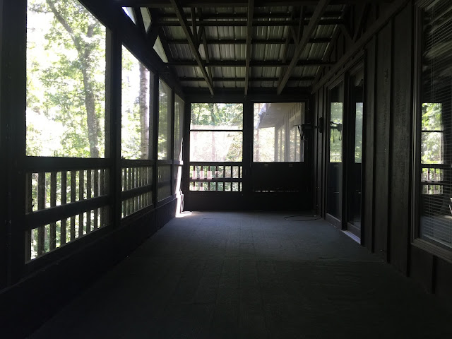 central Minnesota lakeside home with double level porch with dark painted board and batten siding