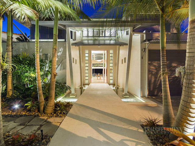 Photo of entrance into the modern villa with palm trees all around it