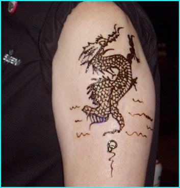 A female having small dragon tattoo on her chest.