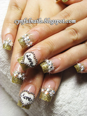 This is an eye-catching and sparkly set of gold nails! The heart design is 