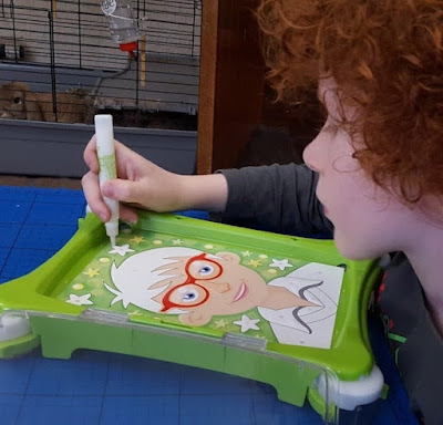 child with revell sand shaker art table