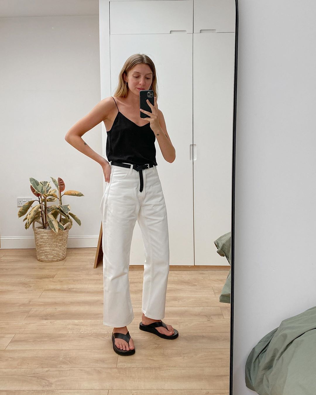 Casual-Chic Outfit Idea — Brittany Bathgate in a black cami, white jeans, and black flip-flops