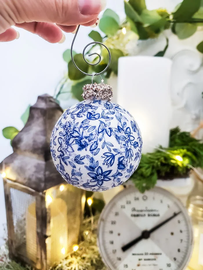 blue and white floral ornament with gold glass glitter top