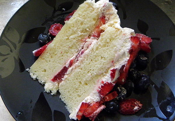 Slice of Berry Whipped Cream Cake on Plate