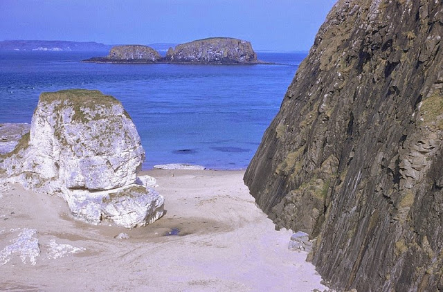 Just E. of Ballintoy Harbour, Co. Antrim. Looking E. Upper Chalk and Tertiary dolerite intrusions just east of Ballintoy Harbour, Co. Antrim. Intrusive plug of Bendoo on right-hand side with chalk stack in centre. Sheep Island still in centre middle distance with Rathlin Island on horizon. View facing east from small cave 200 yd. south-east of Ballintoy Harbour.