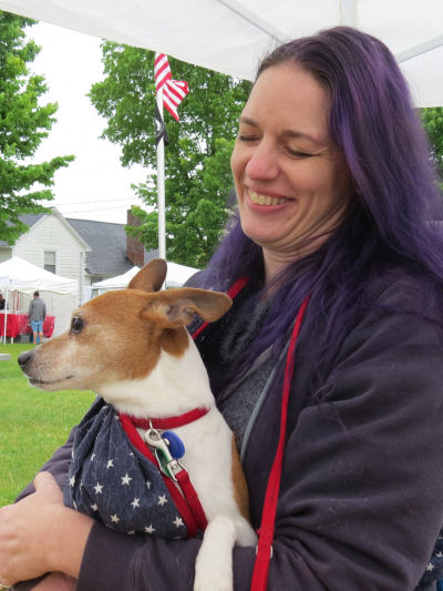 woman with purple hair holding a dog