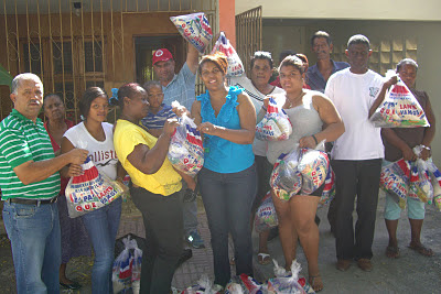 Noris Medina entrega raciones alimenticias en el barrio Villa Estela de Barahona.