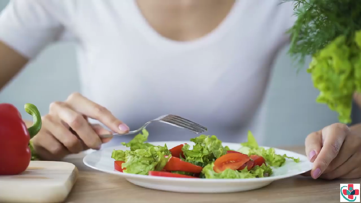 Photo of a girl eating salad.