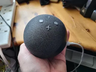 Echo Dot 4th Generation in a hand in an office