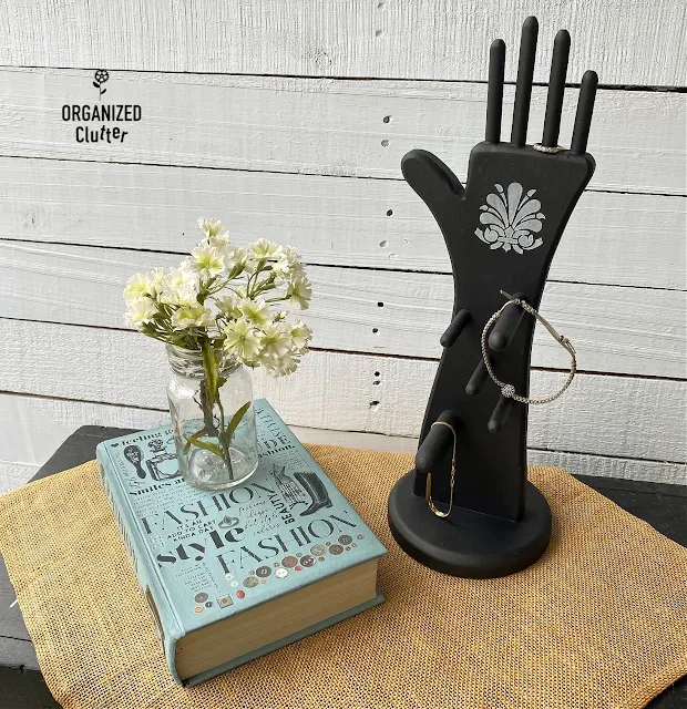 Photo of a stenciled black wooden hand shaped jewelry holder