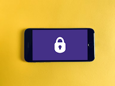A black smartphone on a yellow background showing a purple screen with a white lock icon.