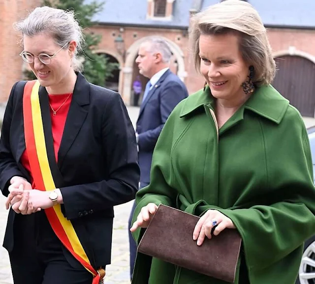 Queen Mathilde wore a green wool coat by Natan, and green wool midi shirt dress by Natan. Dries van Noten. Gold earrings