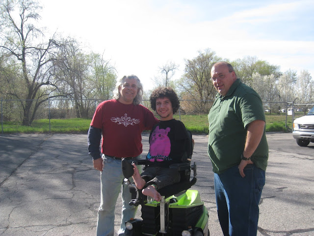 Tom poses with Gideon, a wheelchair recipient.