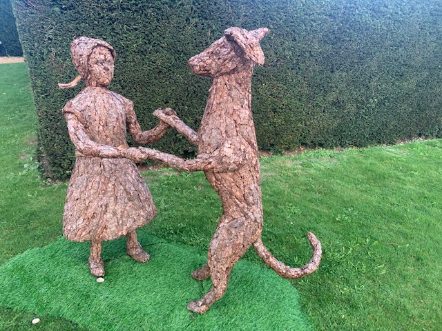 Girl and dog holding hands, made out of willow