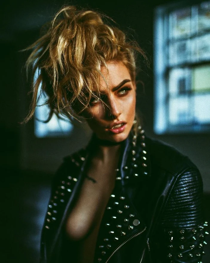 Mercenary Garage Custom Motorcycle Workshop Strawberry Blonde Blue Eyed Girl in Studded Leather Jacket Punk Biker Image by Haris Nukem
