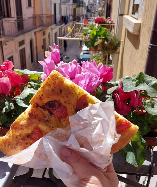 Immagine di una focaccia pugliese e un panorama di una strada street food.