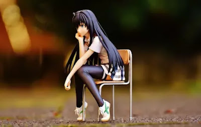 An image of a cute girl sitting on chair with a blur background- sad girl dp