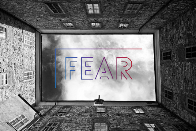 Sky surrounded by buildings with the word "fear" in the middle.