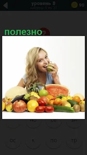  девушка за столом с фруктами и ест полезную грушу
