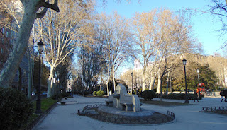 Vista del paseo hacia la p'laza de Cibeles,que ofrece en primer plano vista de una fuente de granito y al fondo el edificio del Ayuntamiento.