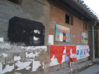 old, frayed signs on the side of a small building