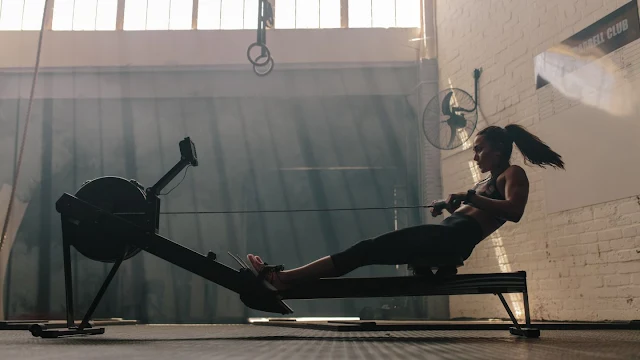 [an image of a woman rowing on a Concept2 Model D ergometer]