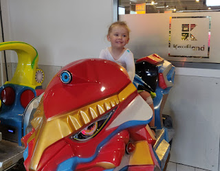 Rosie riding the machine at Kaufland