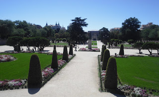 Vista general del jardín desde la cebecera. El monumento a J. Benavente en el cruce de amplios paseos bordeados de parterres y setos recortados.al con el