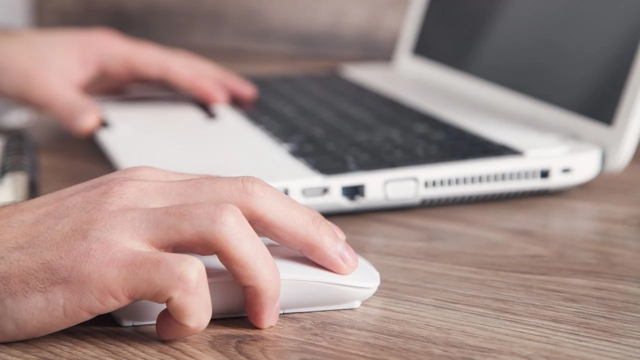 Male hand clicking computer mouse.