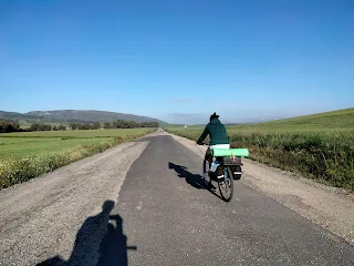 Aim'jie rides on a small asphalt road.