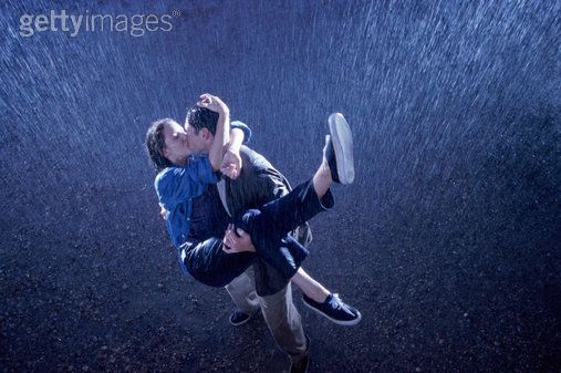 romantic couple kissing in rain. young couple kissing in rain.