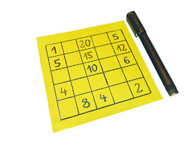 na zdjęciu żółta karta a na niej narysowana tabelka 5x5, w tabelce liczby a obok leży pisak