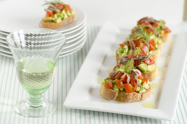 Antipasto di crostini con avocado pomodorini e alici