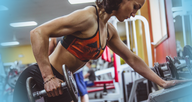 A woman lifting weights in a gym, showcasing strength and determination in her fitness routine.