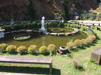 Jardim Baguá com lago, estátua e plantas