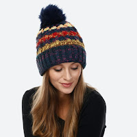 navy blue thick and cozy winter hat with yellow, cream, and red stripes and a big pompom