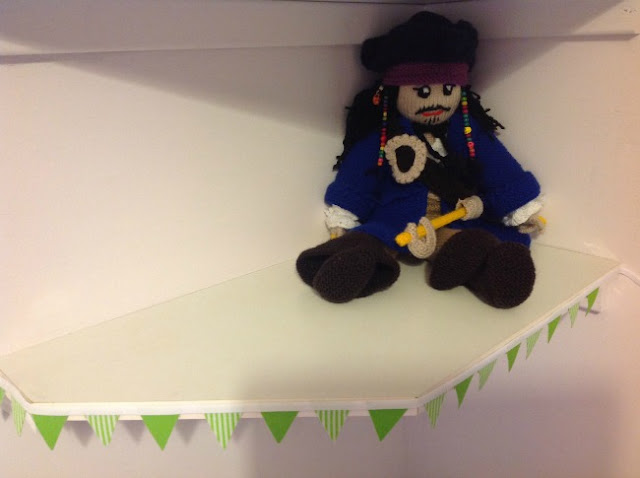 knitted pirate sat on shelf with green bunting as trim