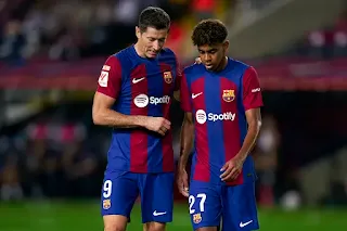 Robert Lewandowski e Lamine Yamal conversam no campo após a vitória emocionante do Barcelona sobre o Atlético de Madrid por 4 a 2.
