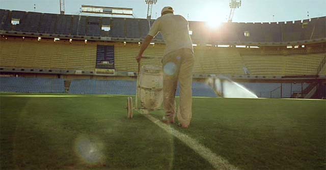 Hombre pintando las rayas de un campo de fútbol