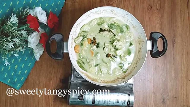 Thai basil leaves being added to a pot of curry as it's seasoned with fish sauce and palm sugar, imparting both flavor and aroma.