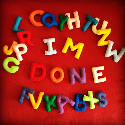 Stuffed felt letters in a variety of colors spelling out I'm Done on a red background