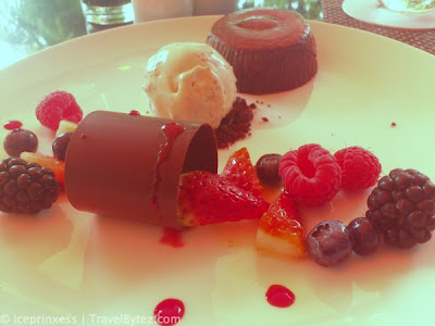 Hazelnut fondant (brownie) with a scoop of ice-cream  drizzled with slices of strawberry and berries, chocolate on the side