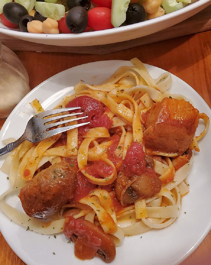 this is a  fettuccine pasta with a rich mushroom pork sauce on top